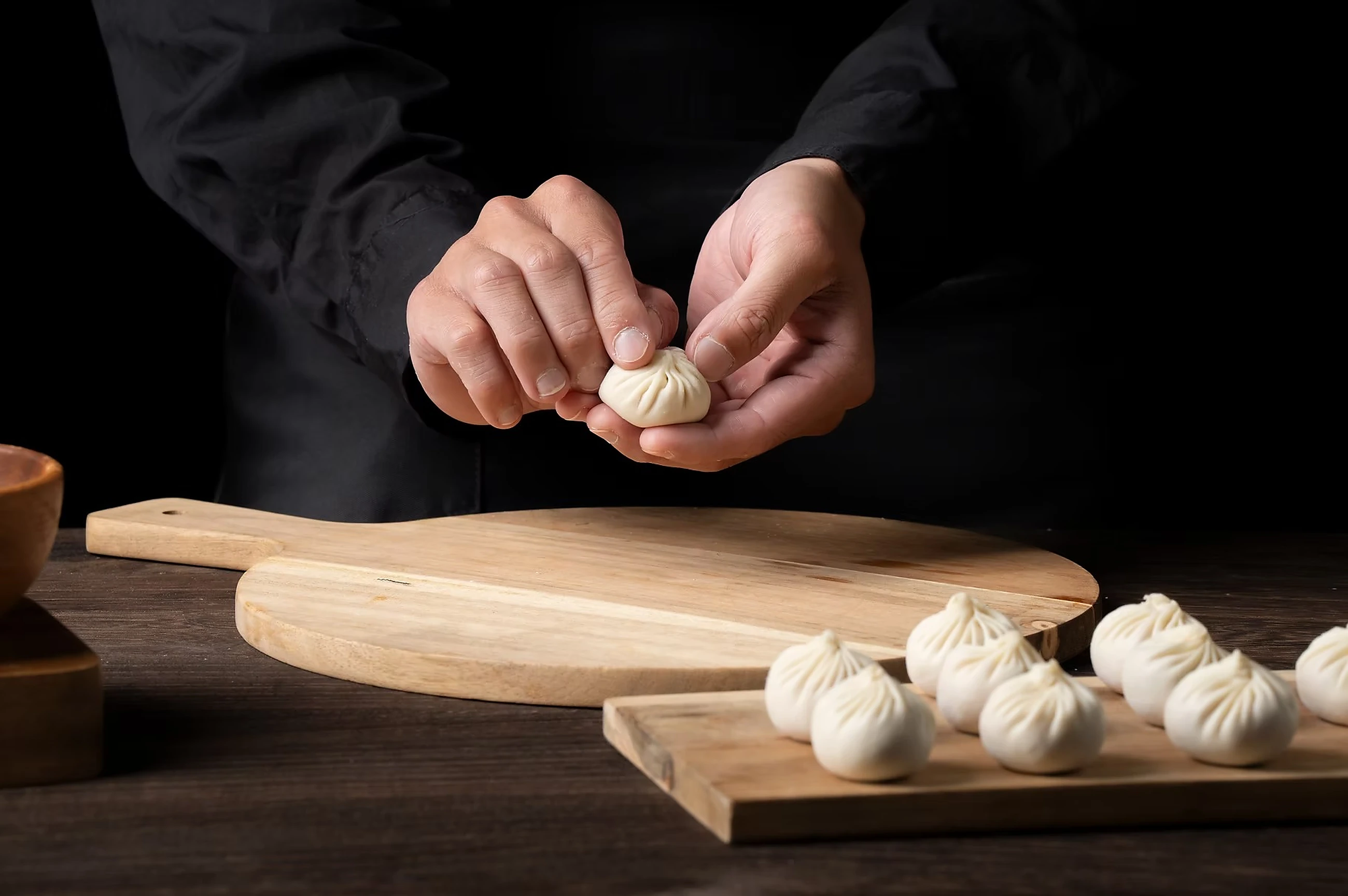 A Supreme Dumplings chef folding Xiao Long Bao by hand